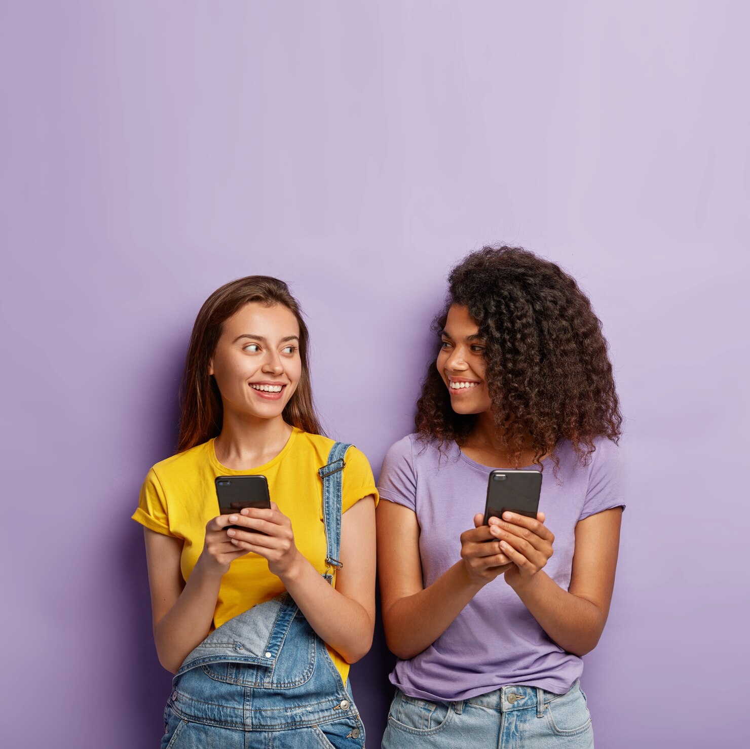 two cute millennial girls use cell phones 273609 31712